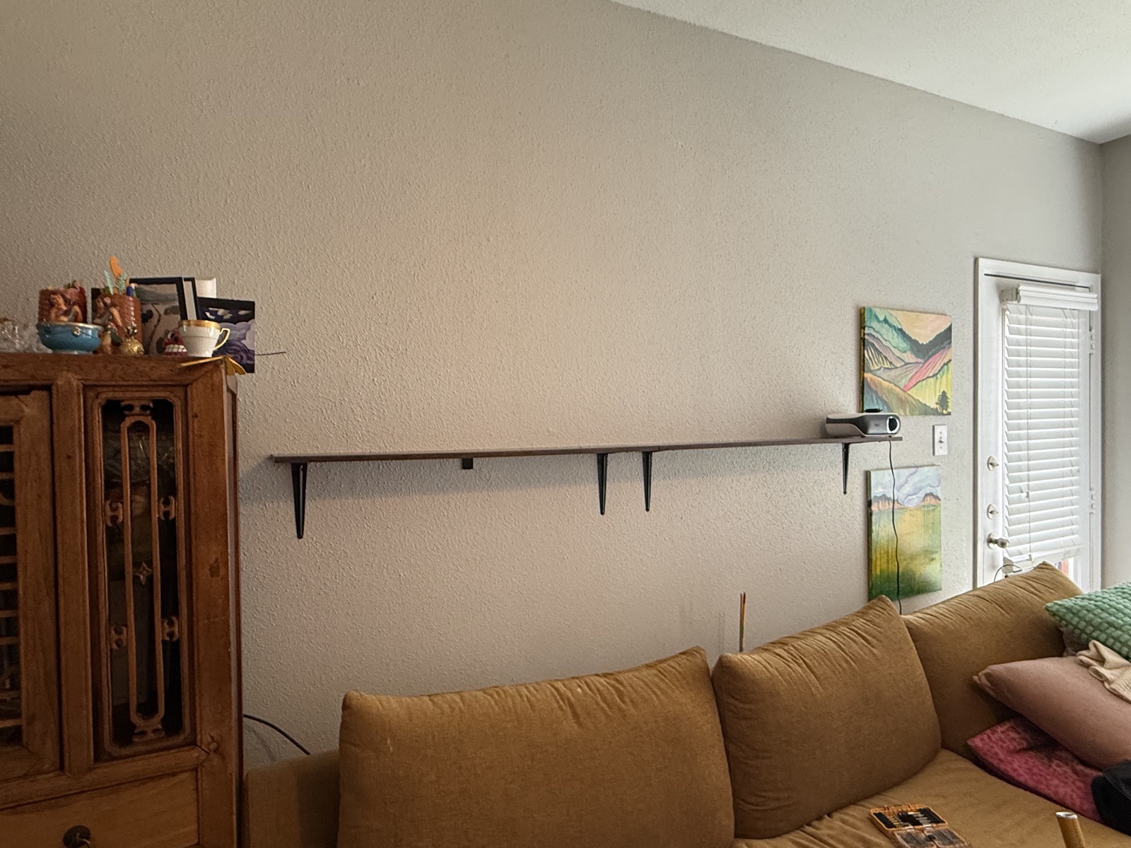 Floating shelf installed across a living room wall