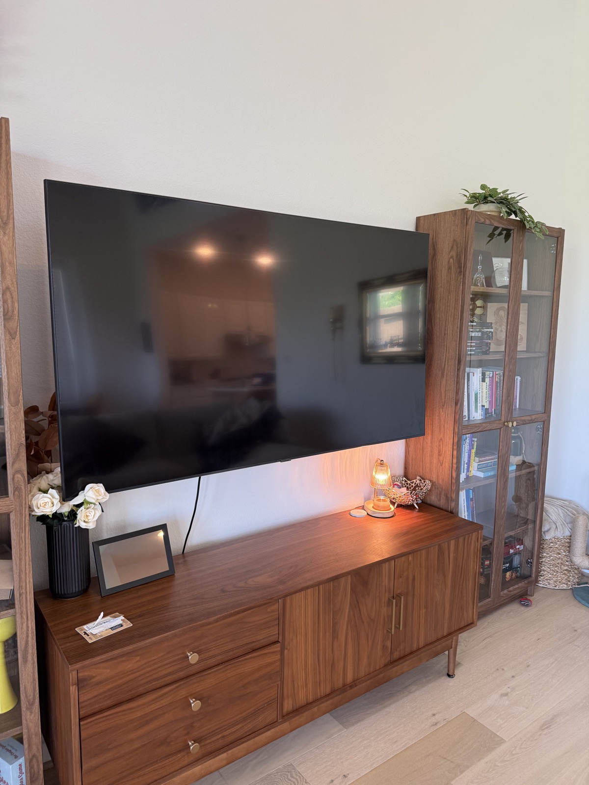 Large flat-screen TV mounted level above a walnut media console