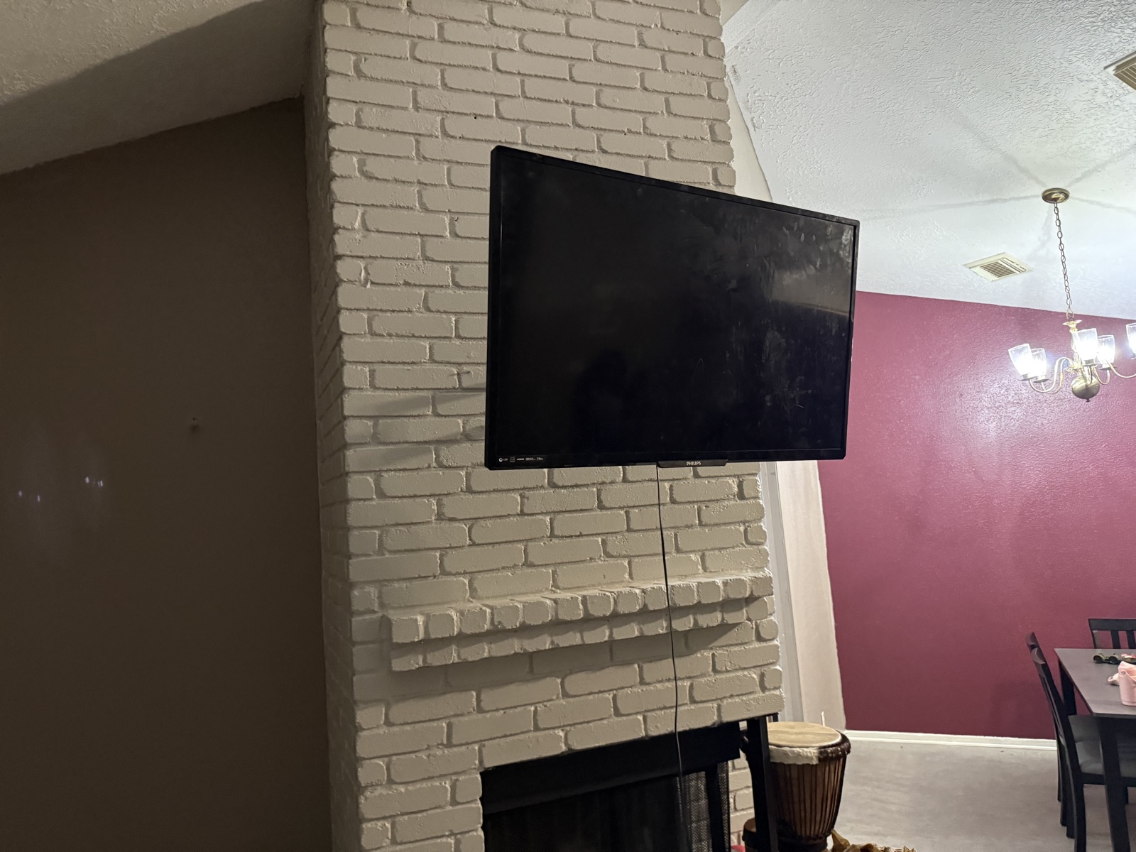 Flat-screen TV mounted on a painted brick fireplace